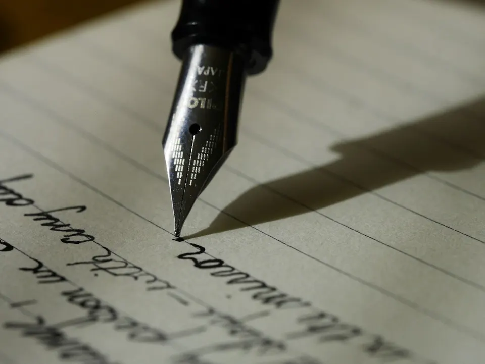 Fountain pen resting on a handwritten notebook