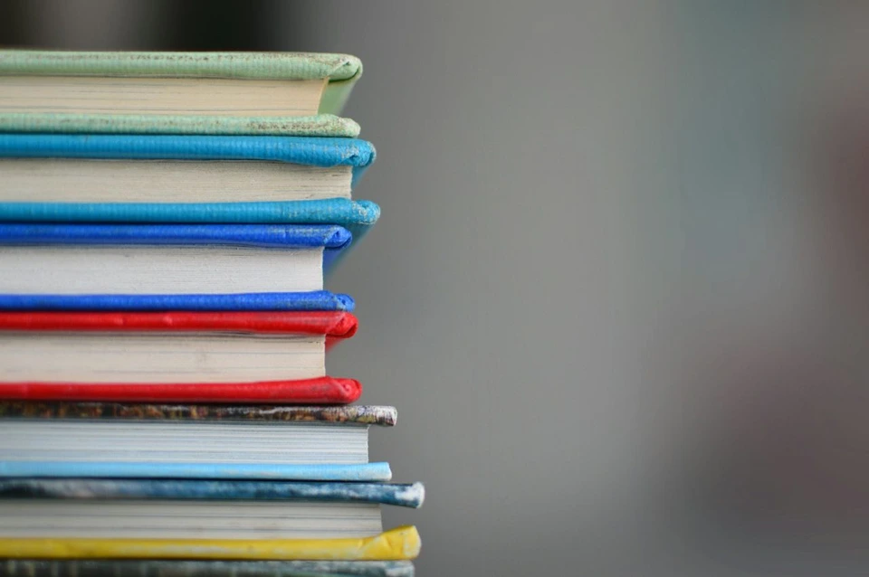 A stack of colourful books against a softly blurred background